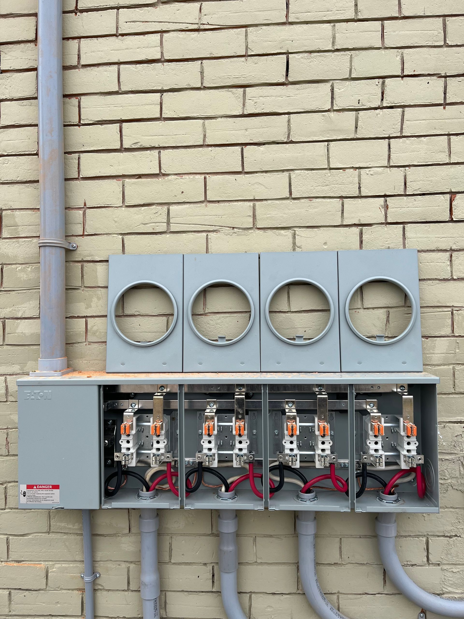 A row of electrical boxes on a brick wall