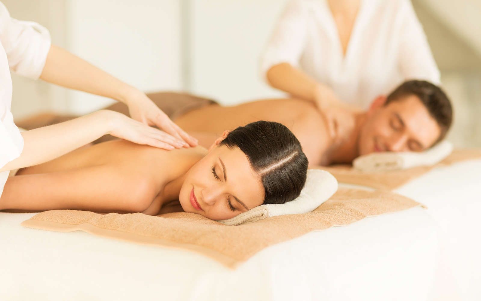 Une femme reçoit un massage de la tête les yeux fermés