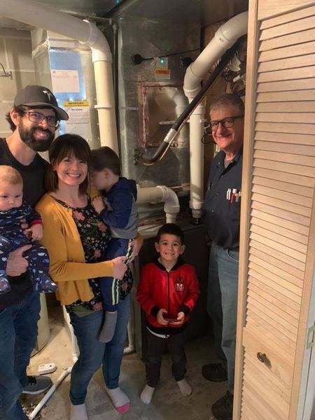 a family is posing for a picture in front of a heater .