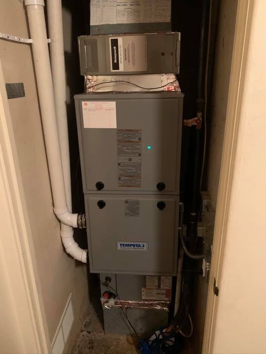 a furnace is sitting in a corner of a room next to a door .
