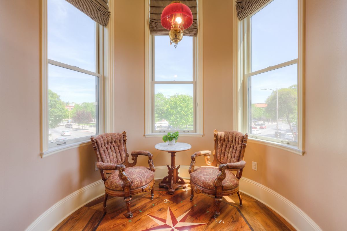 A cozy, light-filled alcove with two armchairs facing each other. A small table sits between them.