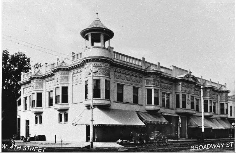 Black and white photograph of a two-story corner building.