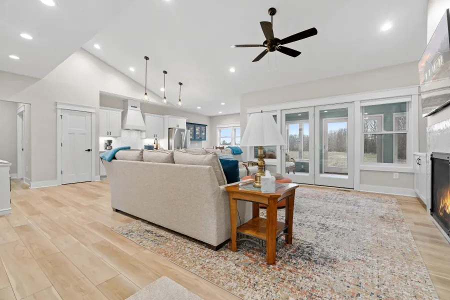 A living room with a couch , table , fireplace and ceiling fan.