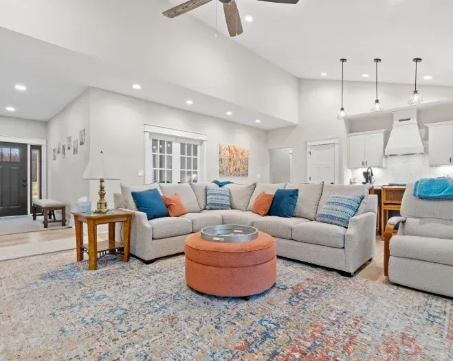 A living room filled with furniture and a ceiling fan.