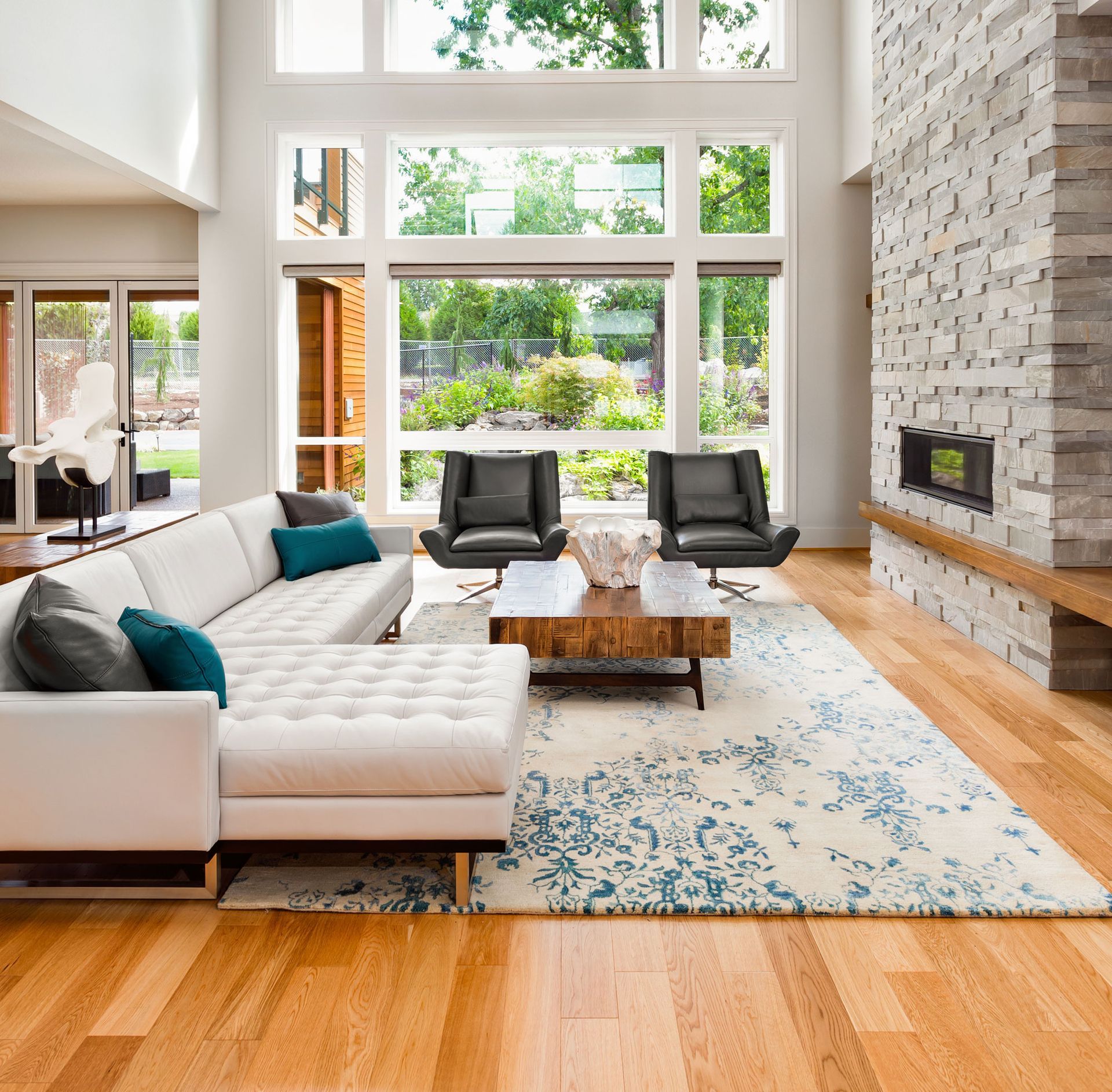 Beautiful living room interior with hardwood floors, huge bank of windows, and fireplace