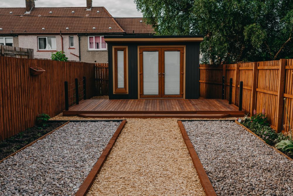 Black Shed with Wooden Deck and Gravel Path in Backyard — Complete Sheds In Campbelltown, NSW