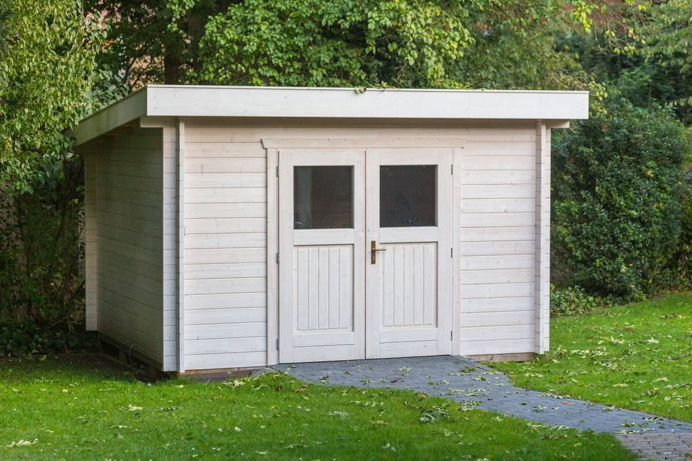 White Shed with Double Doors on A Grassy Lawn, with A Stone Path Leading up To It — Complete Sheds In Dapto, NSW