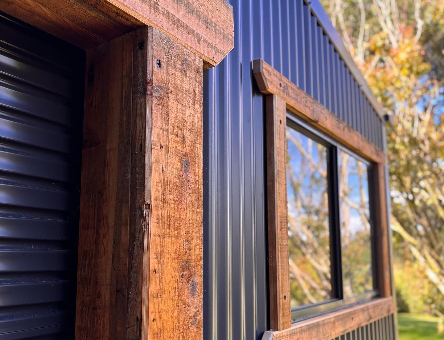 Wooden window frames on a dark corrugated metal building exterior.