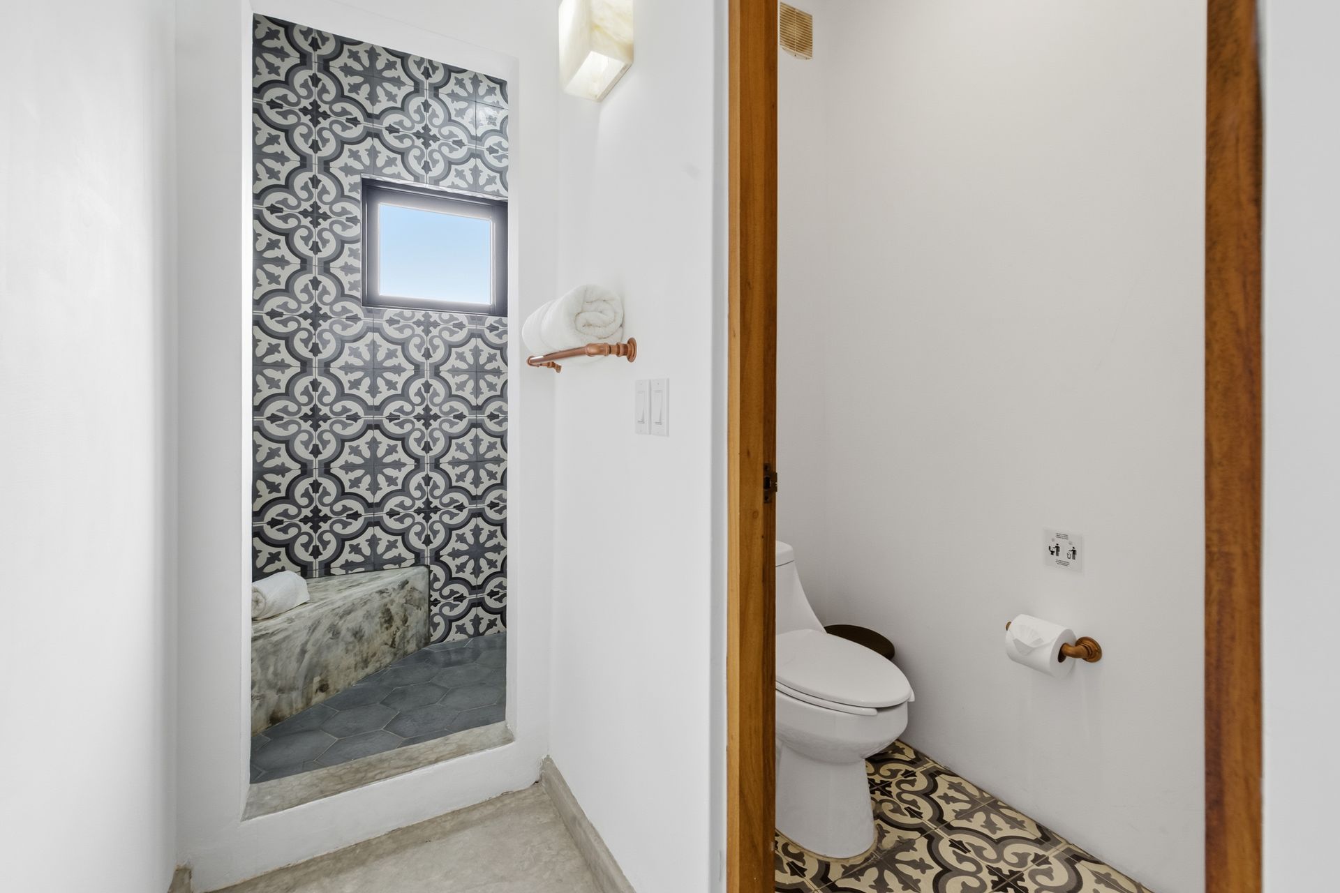 Two bathrooms: one with patterned tiles, one with a toilet and patterned floor, both with white walls and wood frames.