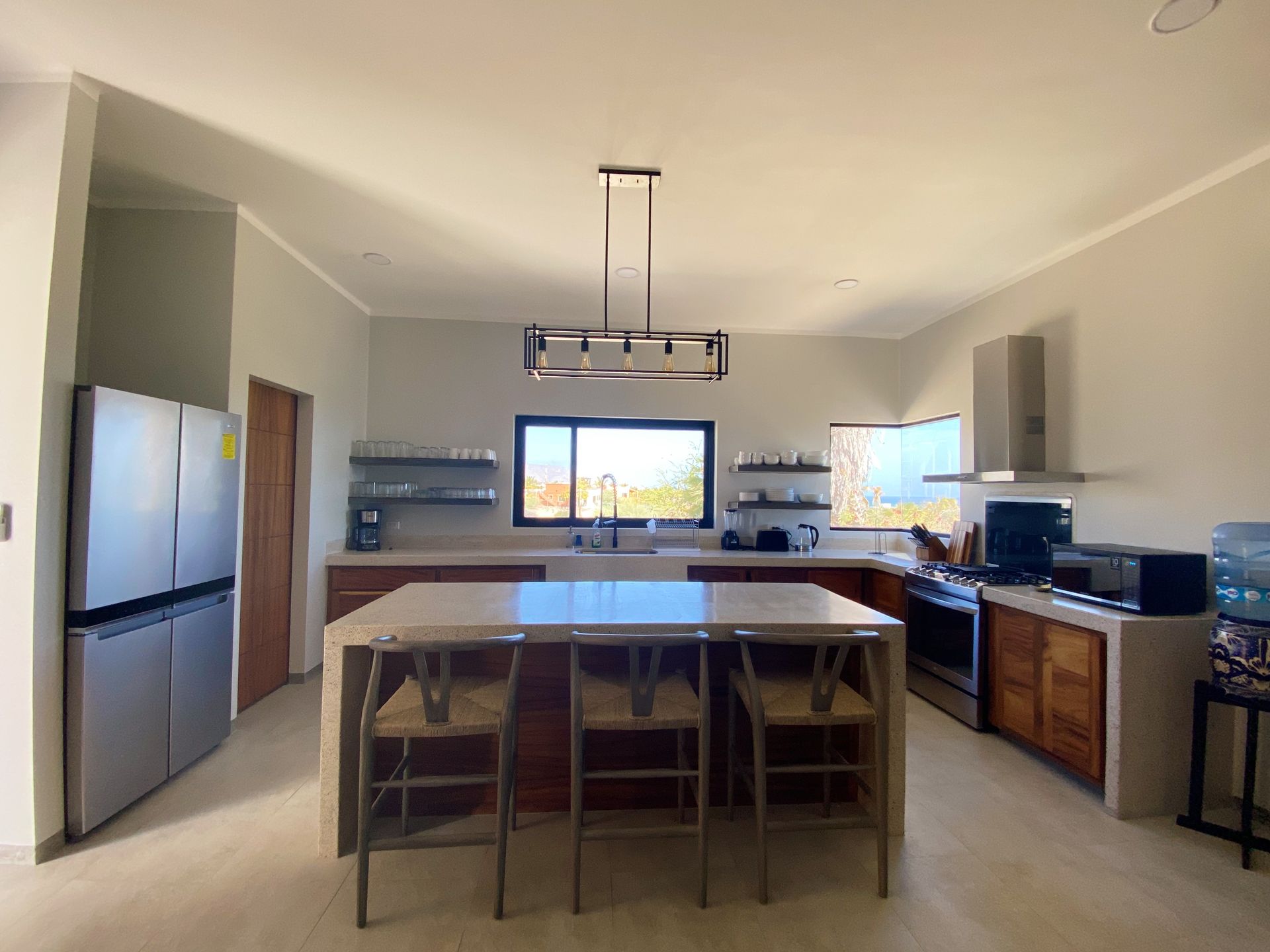 Modern kitchen with island, stainless steel appliances, and wooden cabinets.