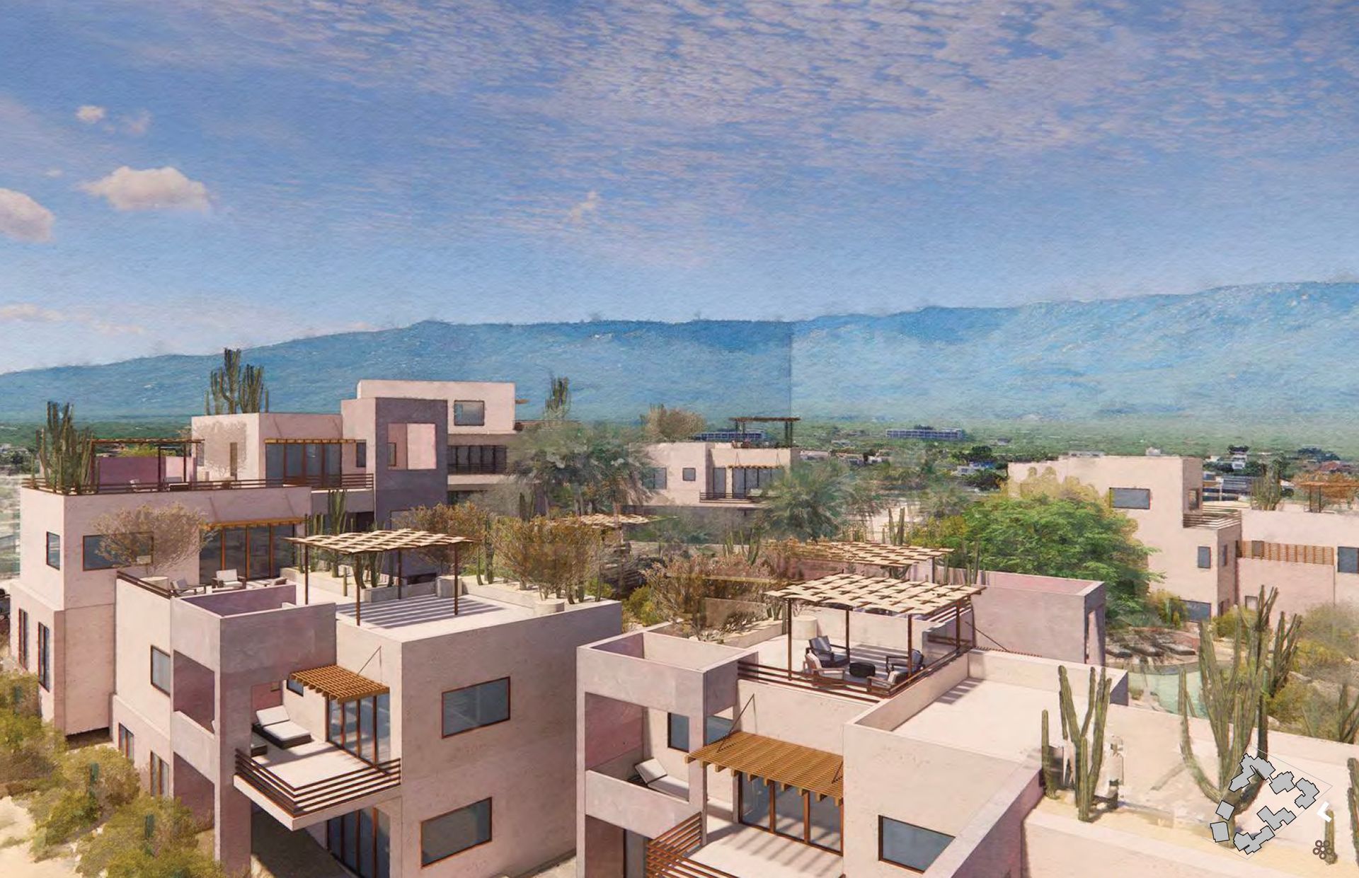 A cluster of pink stucco buildings with flat roofs and shaded patios, set against a mountainous backdrop.