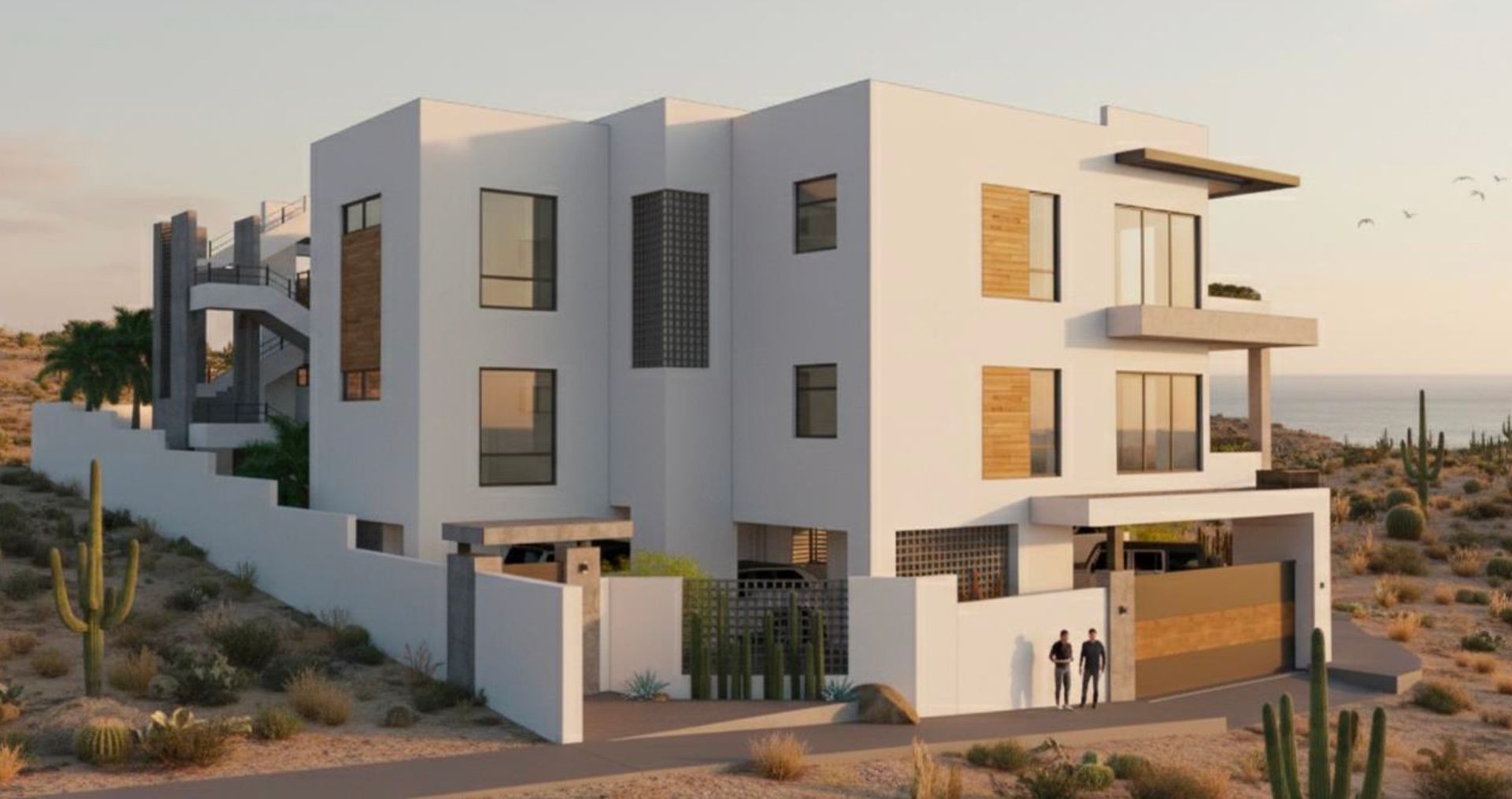 Modern white home on a hillside with desert vegetation and ocean view; two figures stand at the entrance.
