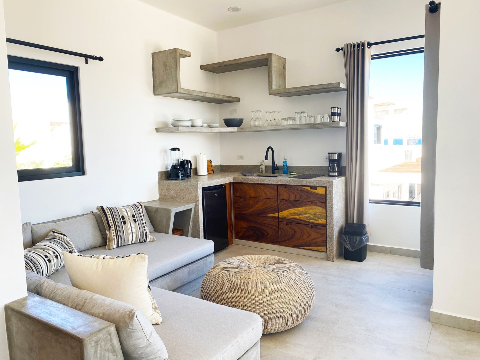 Modern apartment interior with a small kitchen and a gray sofa.