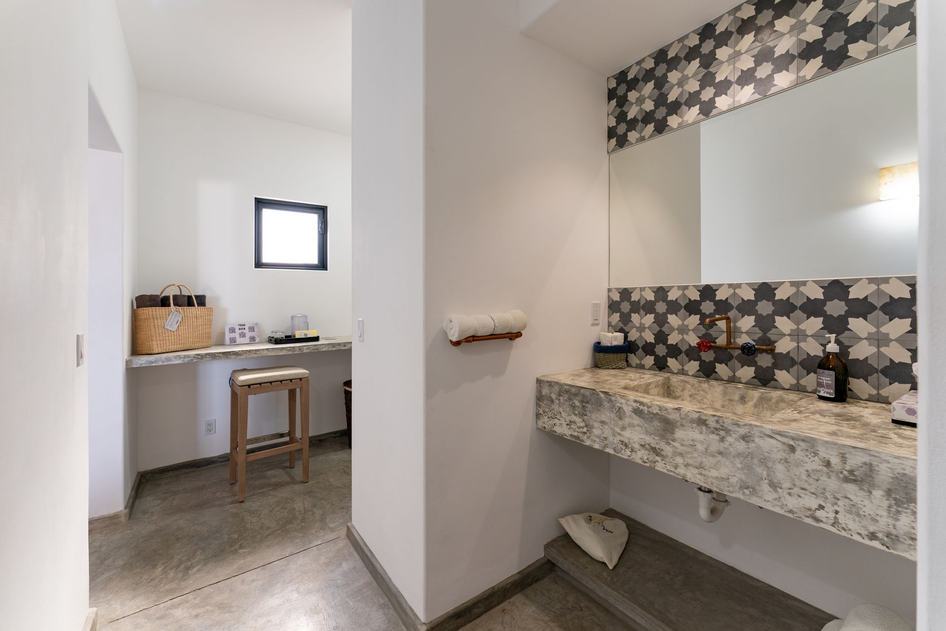 Bathroom with concrete floor and counter, patterned tile backsplash, and a separate vanity area.