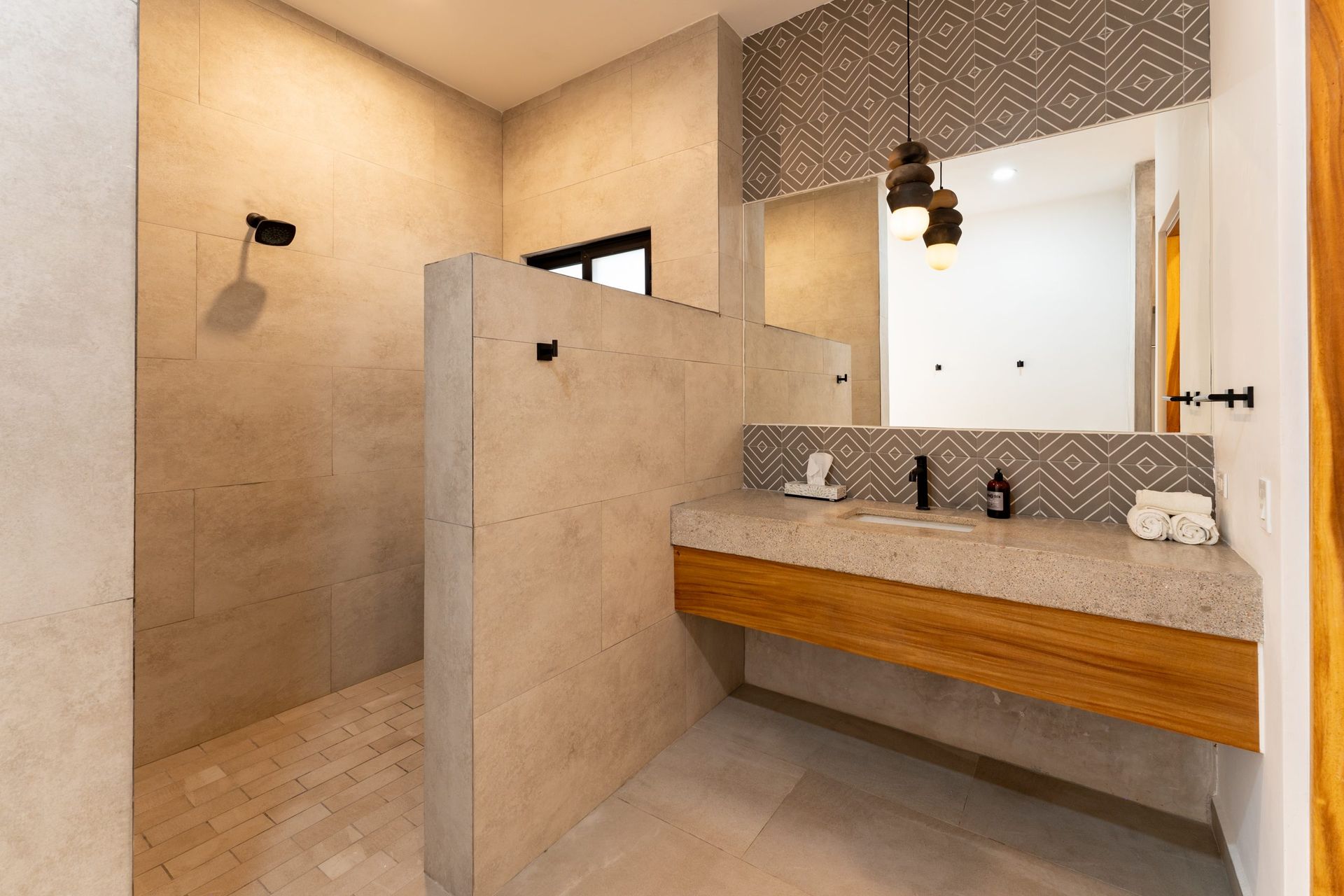 Modern bathroom with stone walls, floating wooden vanity, and shower.
