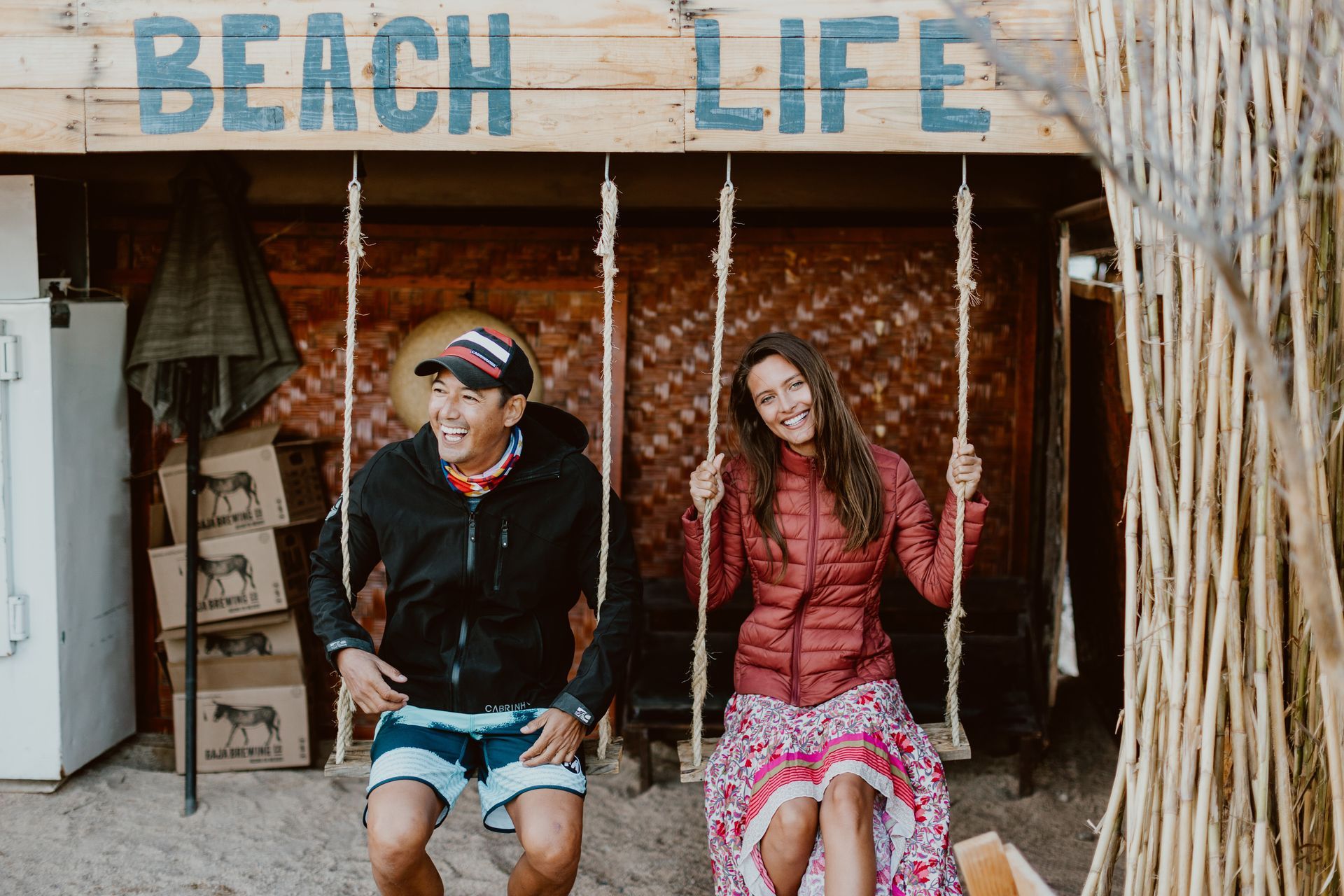 Man and woman smiling, swinging on ropes under a