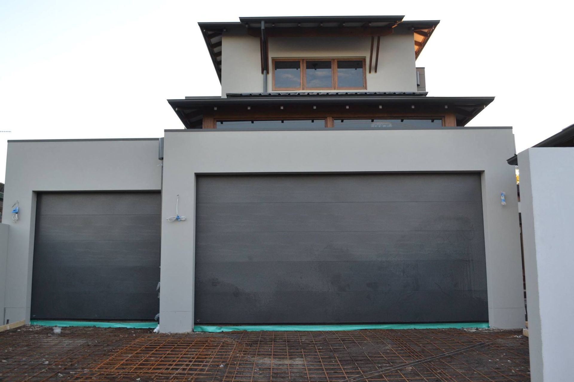A Large White House With Two Black Garage Doors — Gold Coast Door Centre In Burleigh Heads, QLD