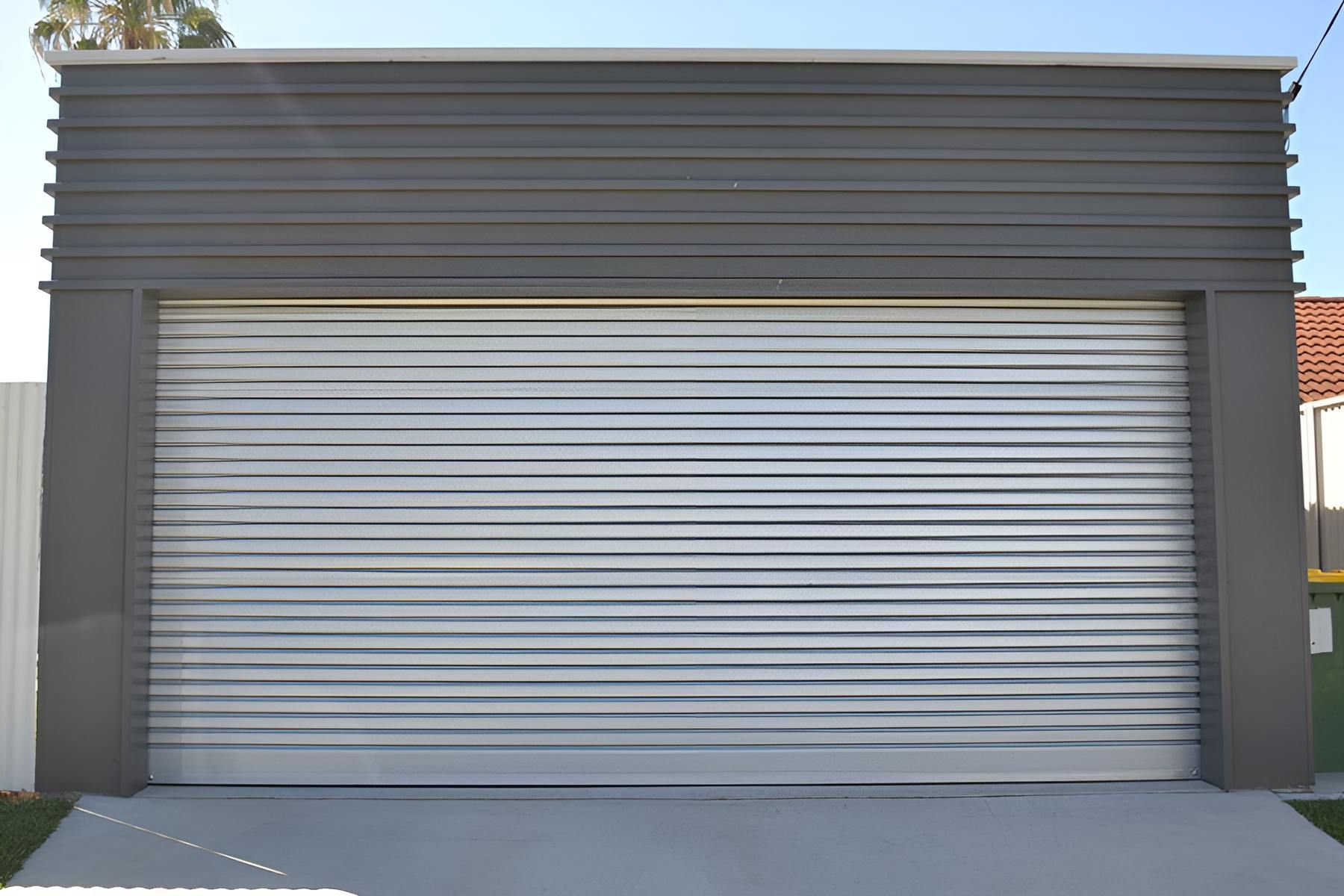 A Garage With A Gray Siding And A Silver Garage Door — Gold Coast Door Centre In Burleigh Heads, QLD