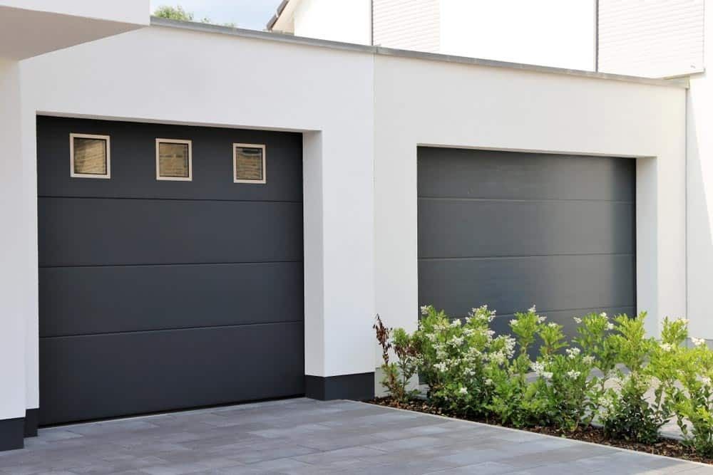 A Couple Of Garage Doors Are Sitting Next To Each Other In Front Of A House — Gold Coast Door Centre In Burleigh Heads, QLD