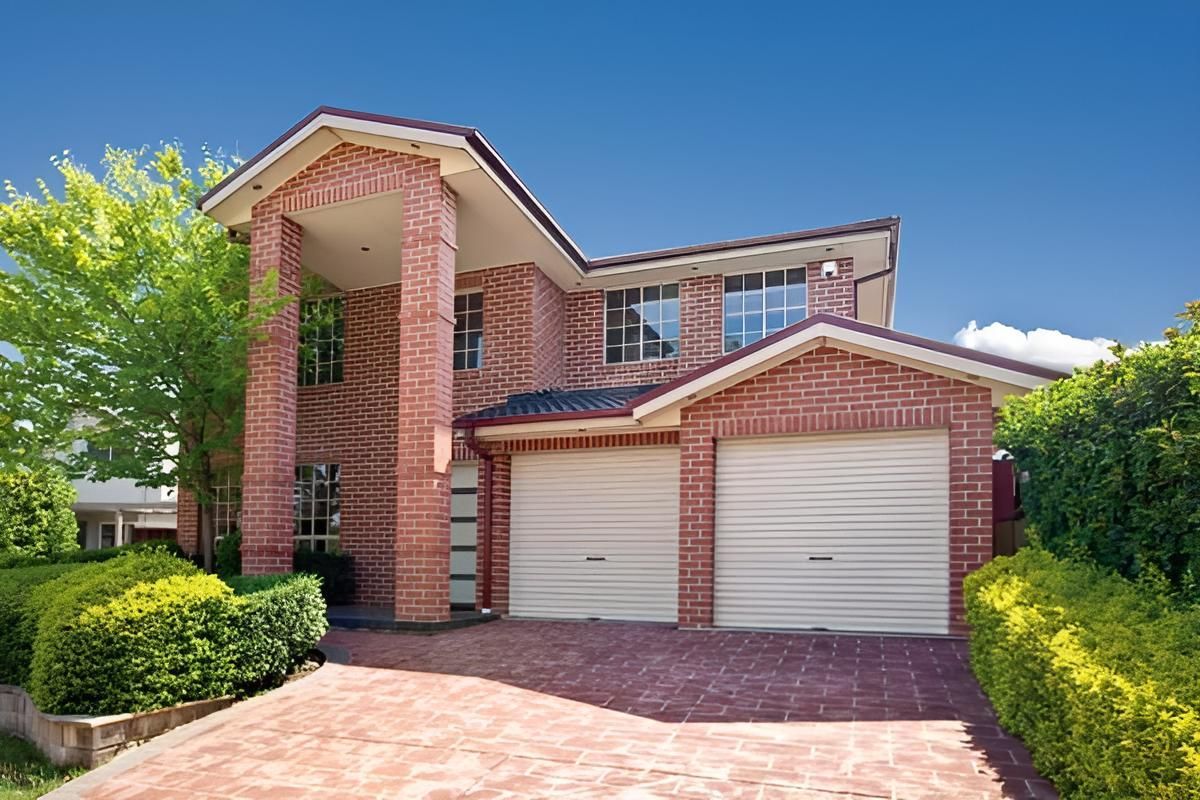 A Large Red Brick House With Two White Garage Doors — Gold Coast Door Centre In Burleigh Heads, QLD