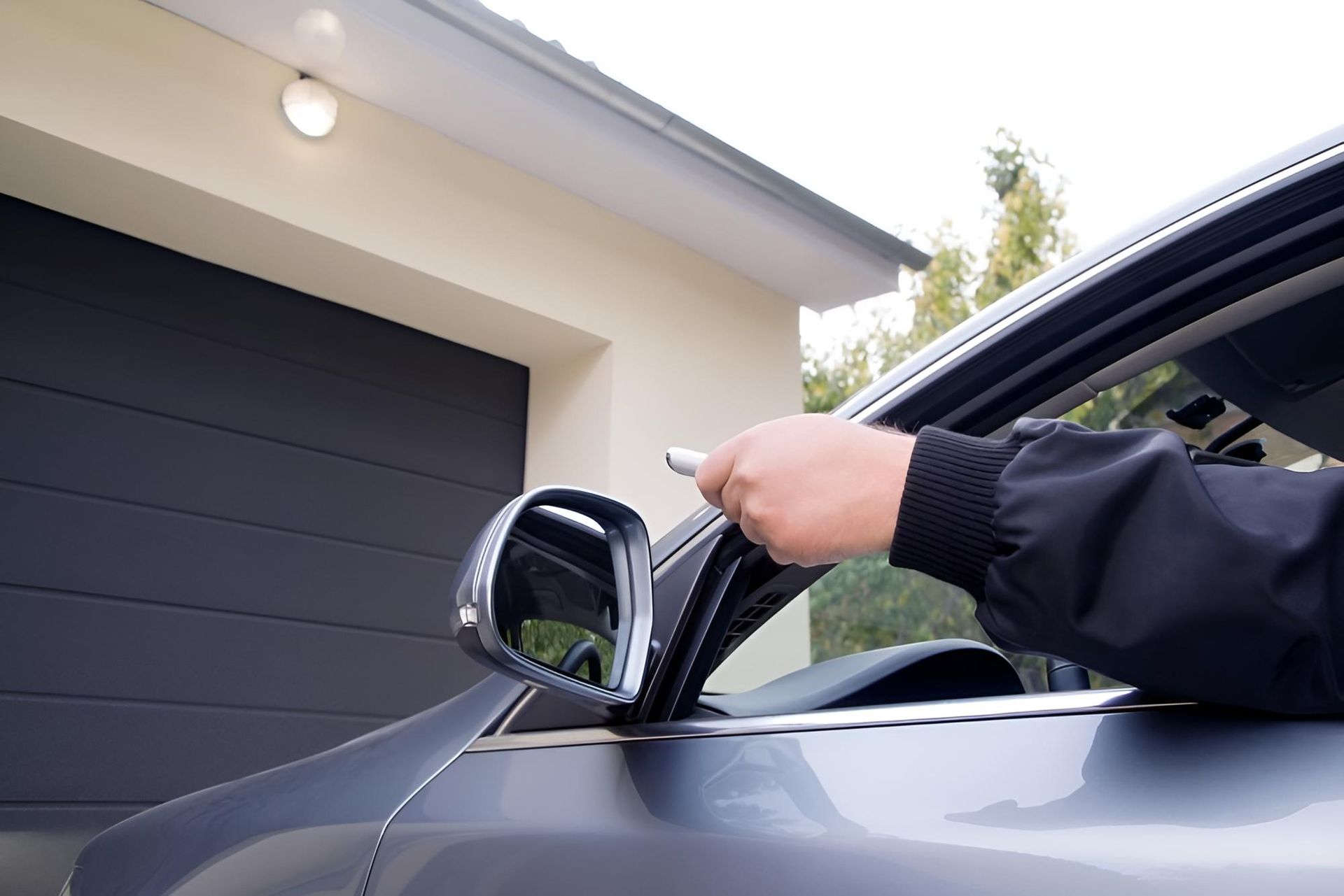 A Person Is Opening A Car Door With A Remote Control — Gold Coast Door Centre In Burleigh Heads, QLD