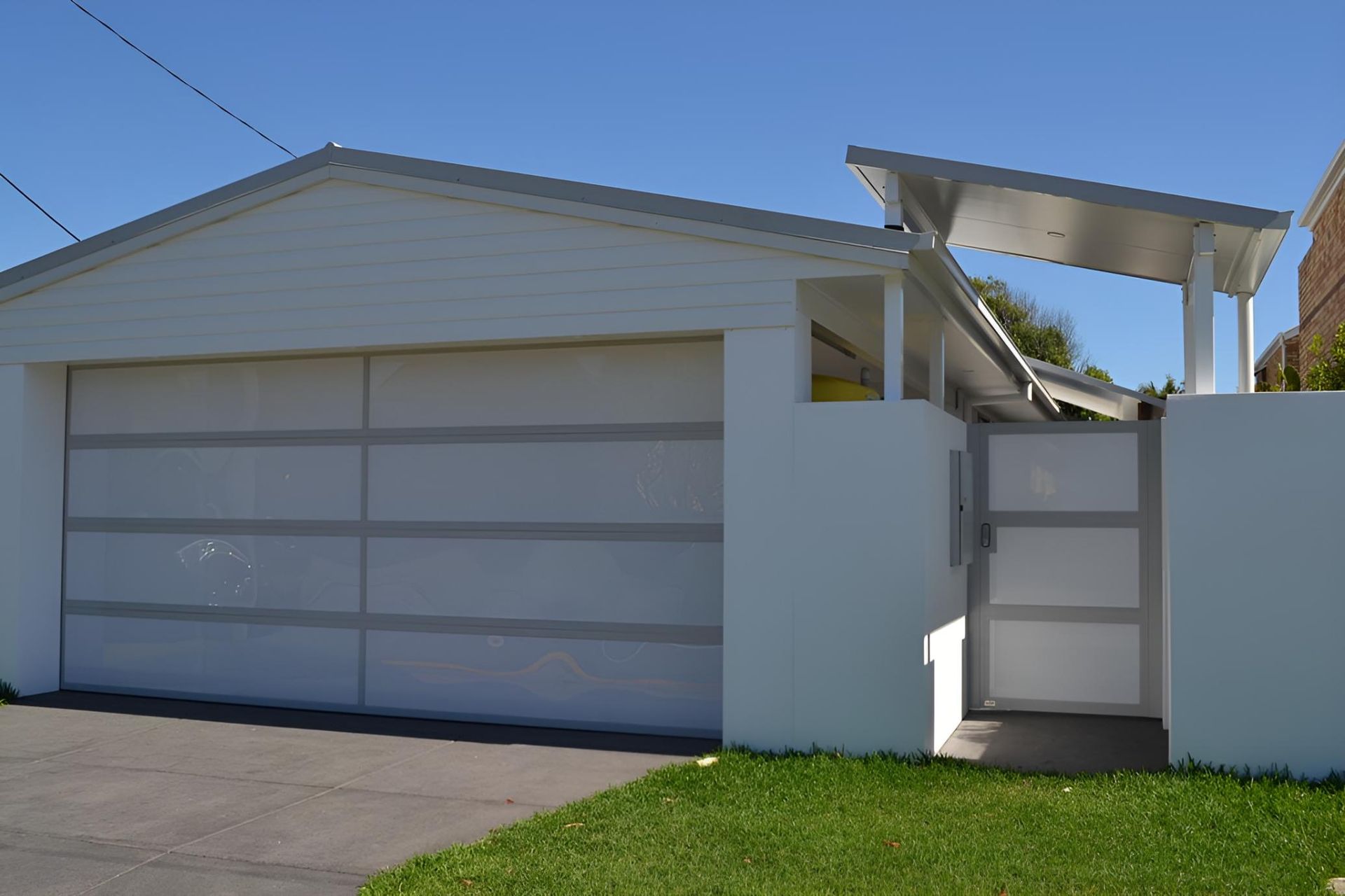 A White House With A Garage Door And A Gate — Gold Coast Door Centre In Burleigh Heads, QLD