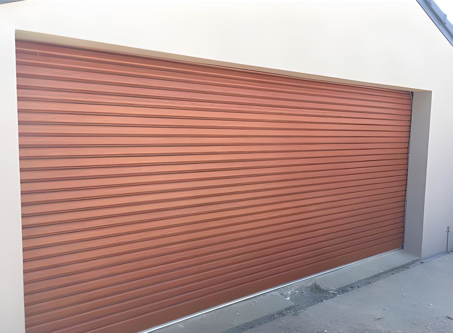 Closed Brown Roll-Up Garage Door On A White Building Exterior