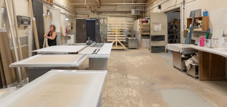 A woman is standing in a woodworking shop.