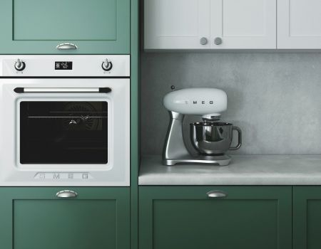 A kitchen with green cabinets and a white oven and mixer.