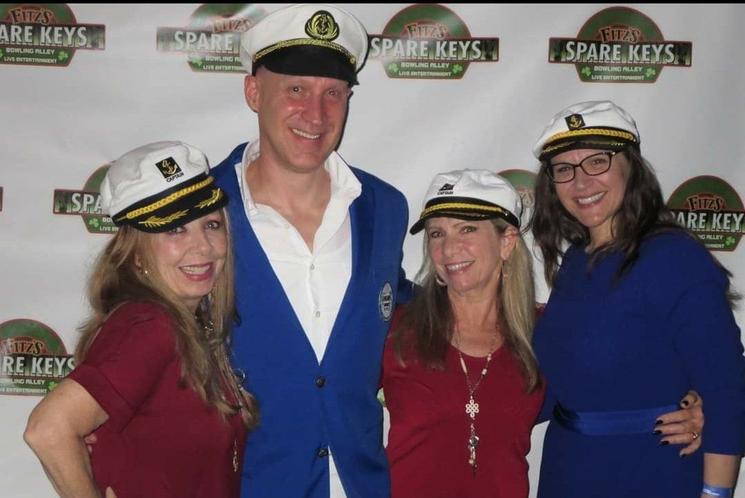 A group of people posing for a picture in front of a wall that says space keys