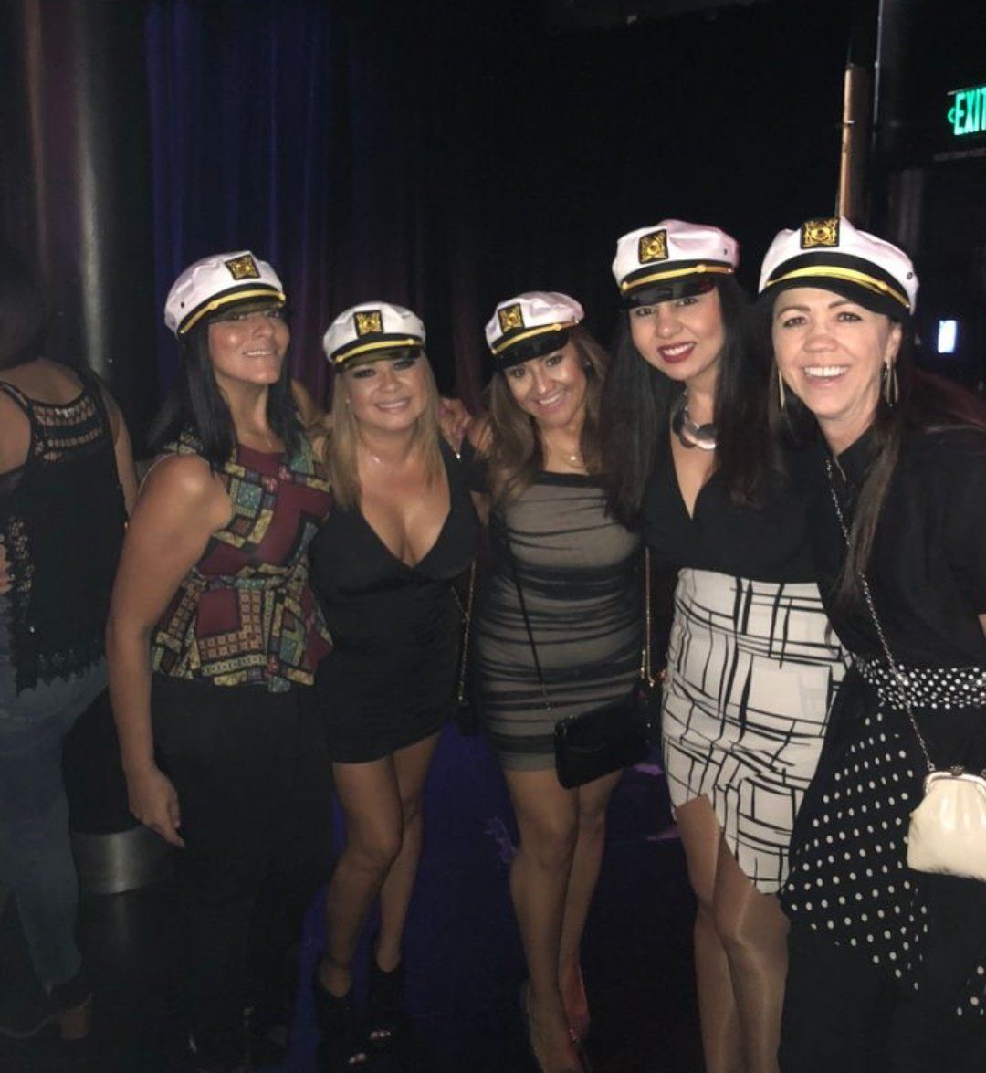 A group of women wearing captain hats pose for a picture