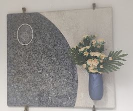 Un vaso blu pieno di fiori è appeso a una parete.