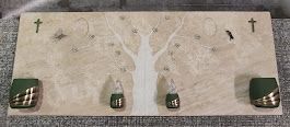 Una tavola di legno con un albero e delle croci sopra.