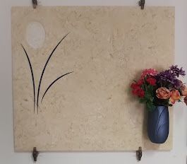 Un vaso di fiori è appeso al muro accanto a una targa.