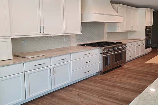 A kitchen with white cabinets and stainless steel appliances.