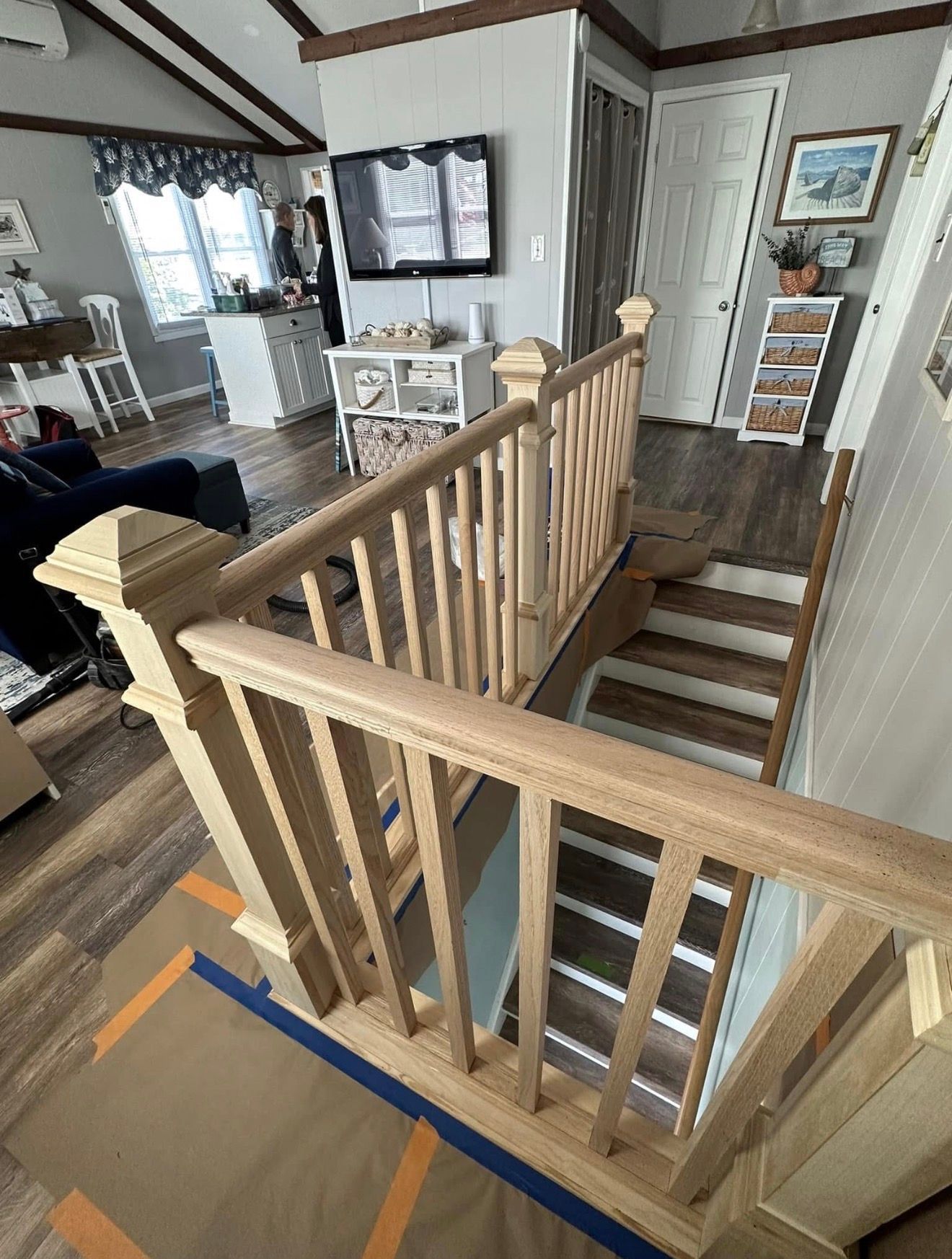 Wooden staircase with a newly installed railing, leading down into a home.