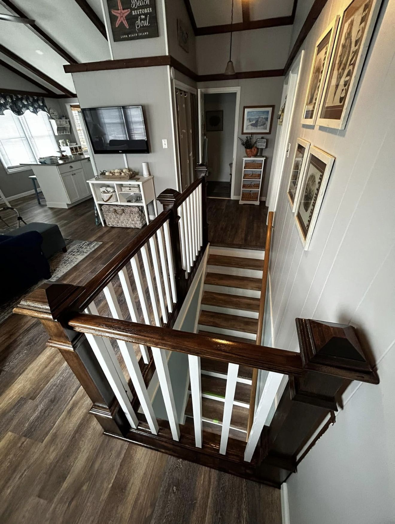 Interior view of a staircase with dark wood and white railings, leading to a lower level.