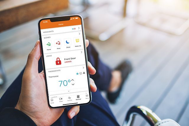 Interior with security cameras and monitor displaying multiple views. Office with sofa, desk, and brick wall.