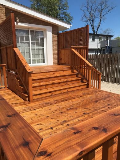 A wooden deck with stairs leading up to a house