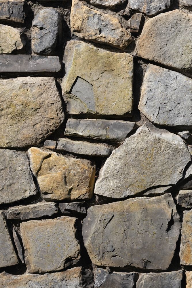 A close up of a stone wall with a lot of rocks