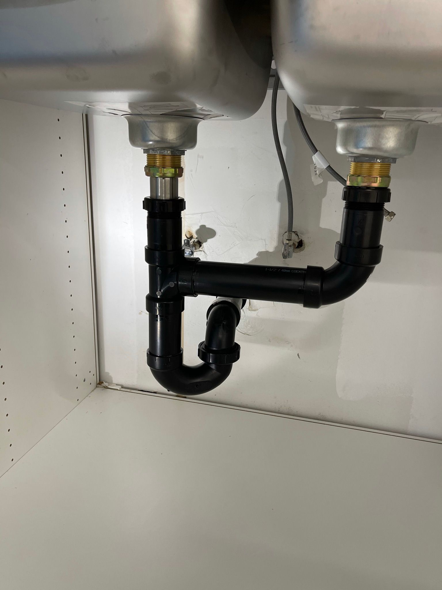 Un évier avec un tuyau noir en dessous