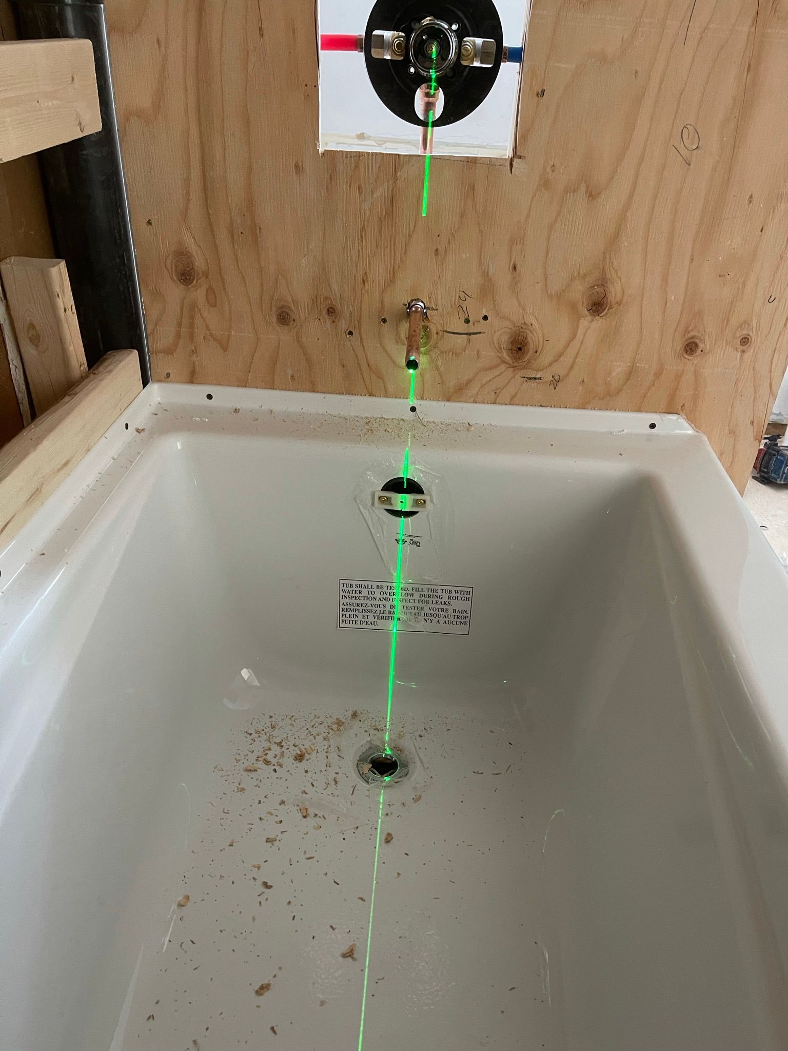 Une baignoire avec une ligne verte sortant du drain.