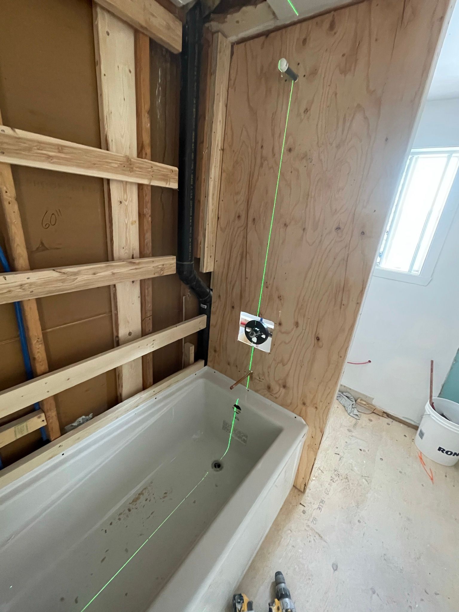 Une baignoire est posée dans une salle de bain en construction.