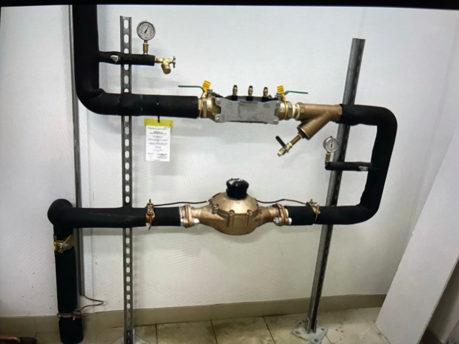 Un tas de tuyaux sont fixés à un mur