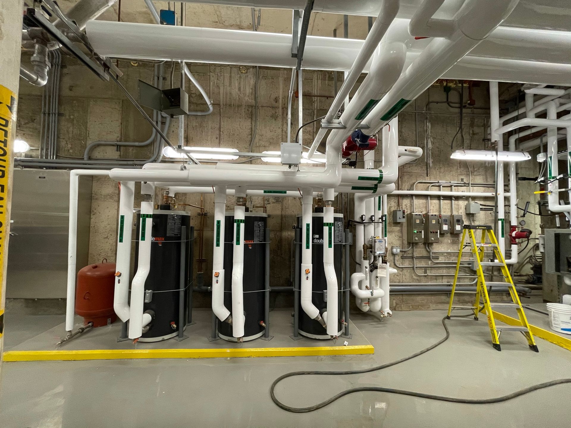 Un homme se tient devant un tas de tuyaux et de vannes.