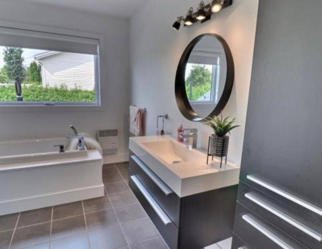 Une salle de bain avec un lavabo, une baignoire et un miroir