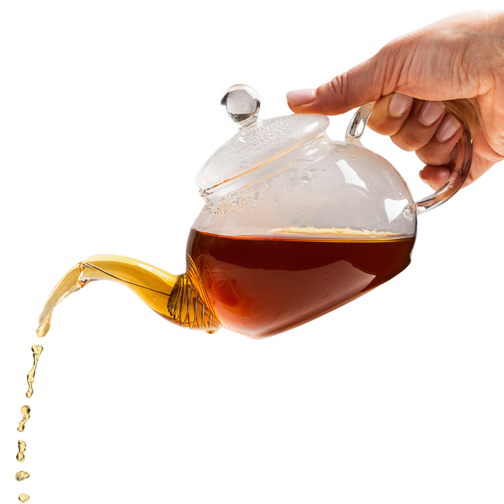 A hand is pouring tea into a glass teapot