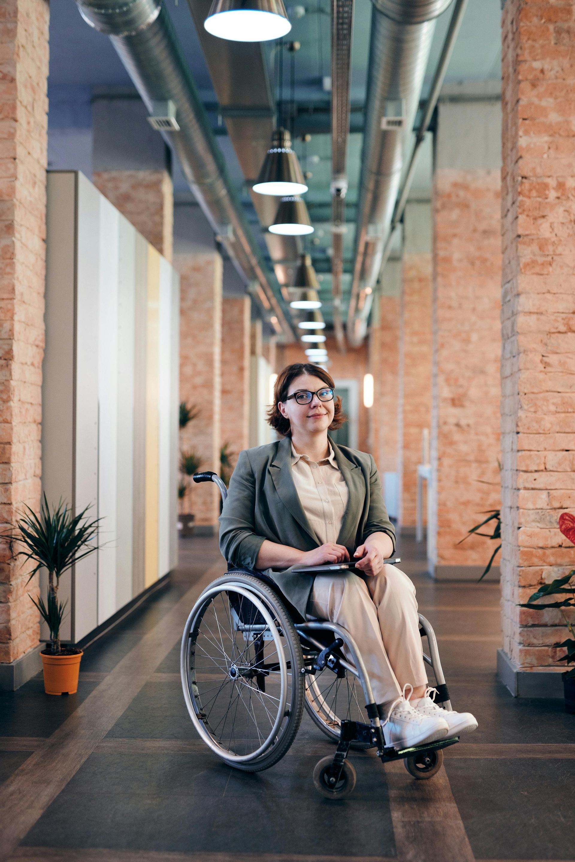 Une femme est assise dans un fauteuil roulant dans un couloir.