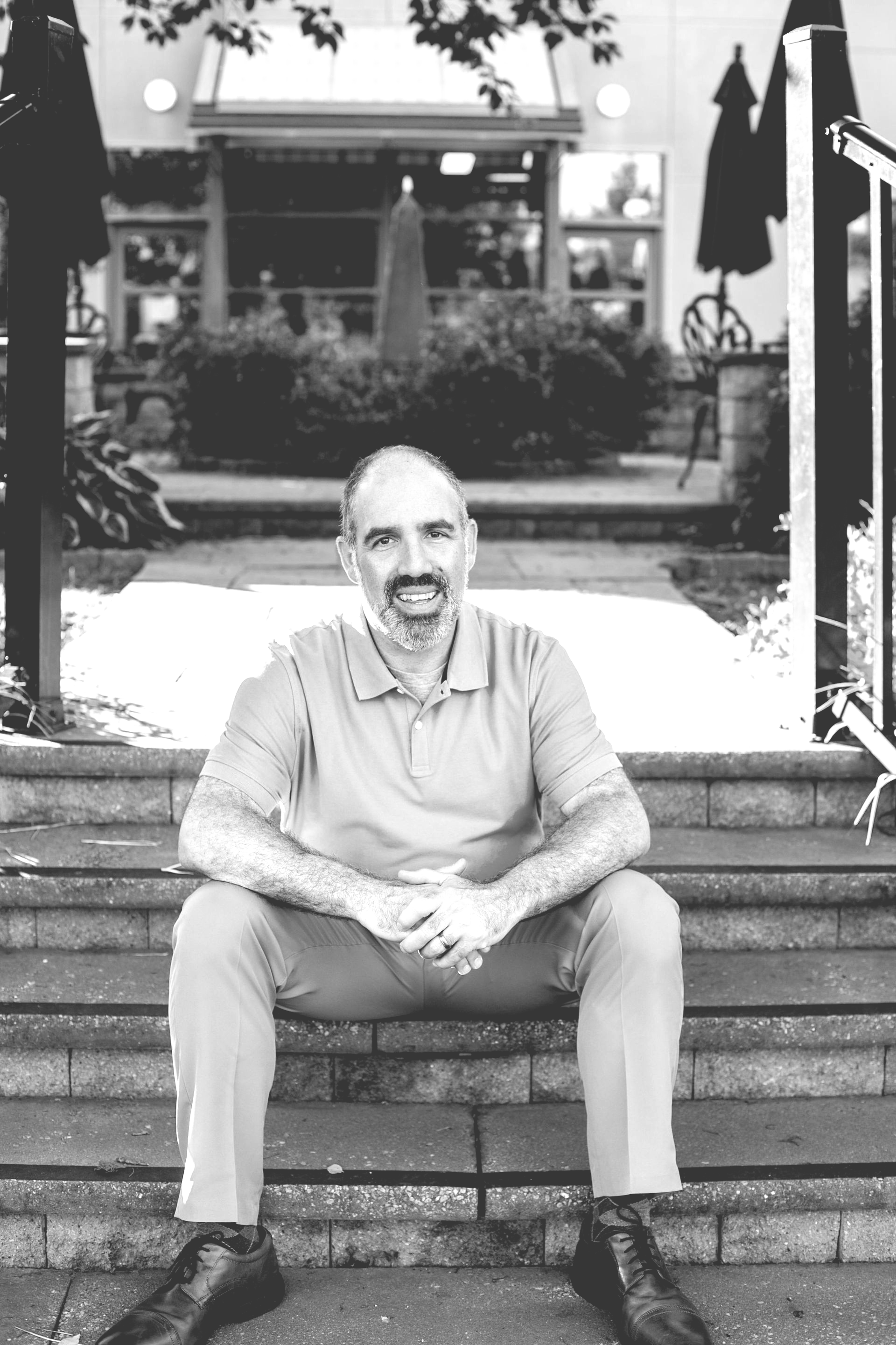 A man is holding a cat in his arms in a black and white photo