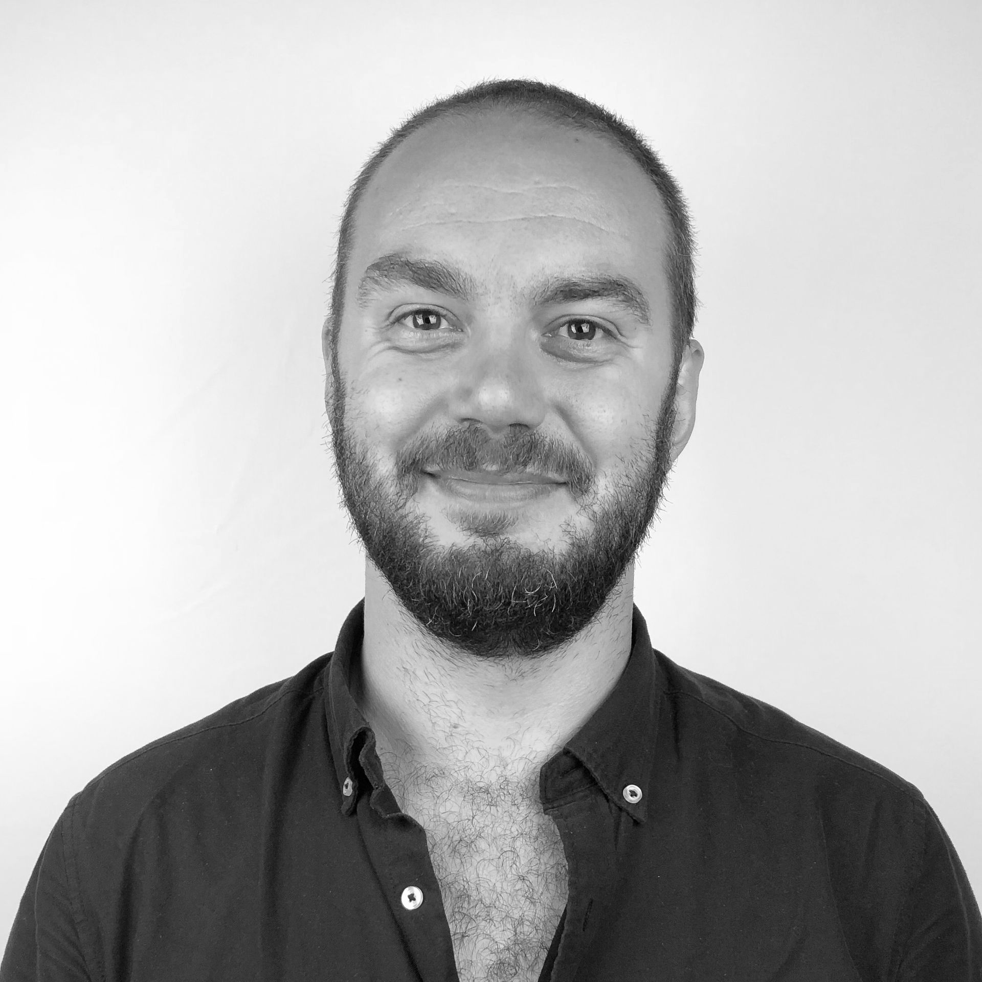 A man is holding a cat in his arms in a black and white photo